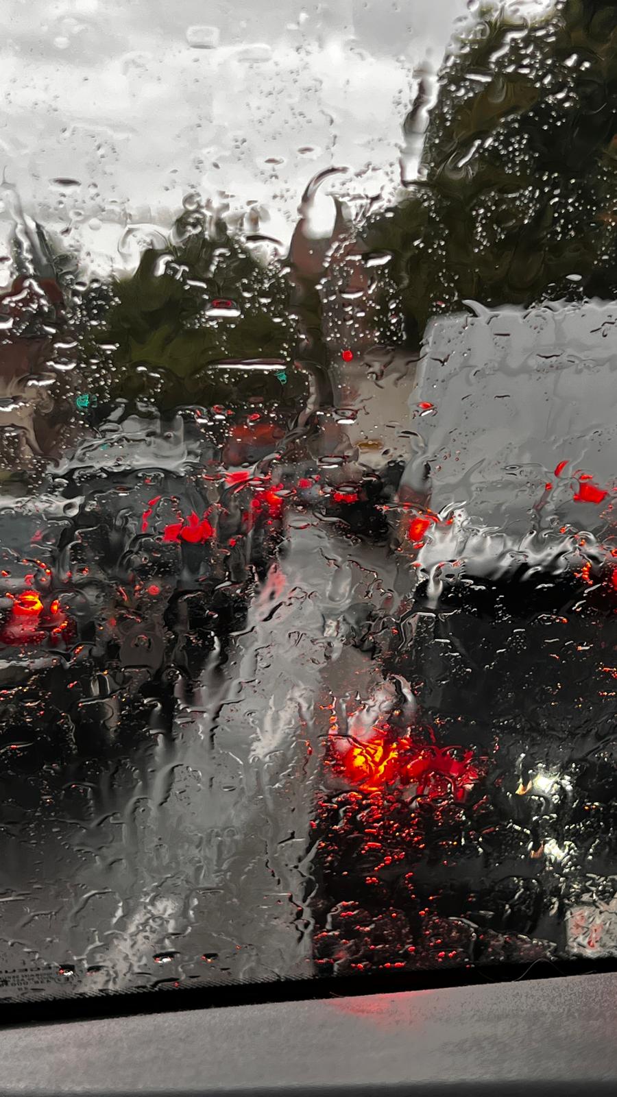 Hochzeit bei Regen, Blick durch eine regennasse Autoscheibe auf die Straße